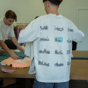 Modelo oversized de manga curta, com estampados de cidades nas costas. Cor branco/crú. Confecionada em tecido macio, com acabamento de alta qualidade.