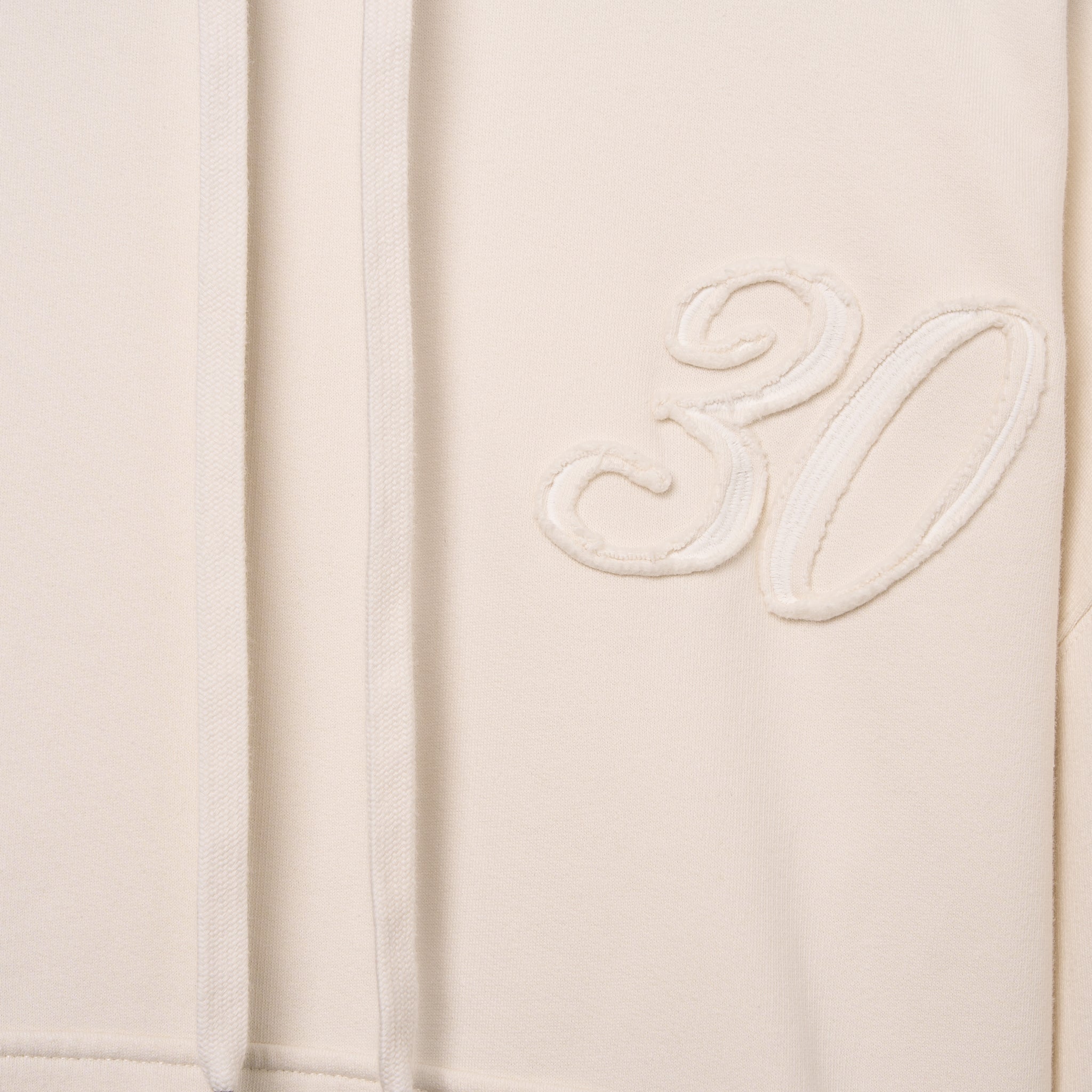Sweatshirt unissexo com capuz da marca 30Fied, em tons de branco sujo. Modelo de manga comprida  oversized. Tecido confortável, modelo com capuz e com cordões ajustáveis.